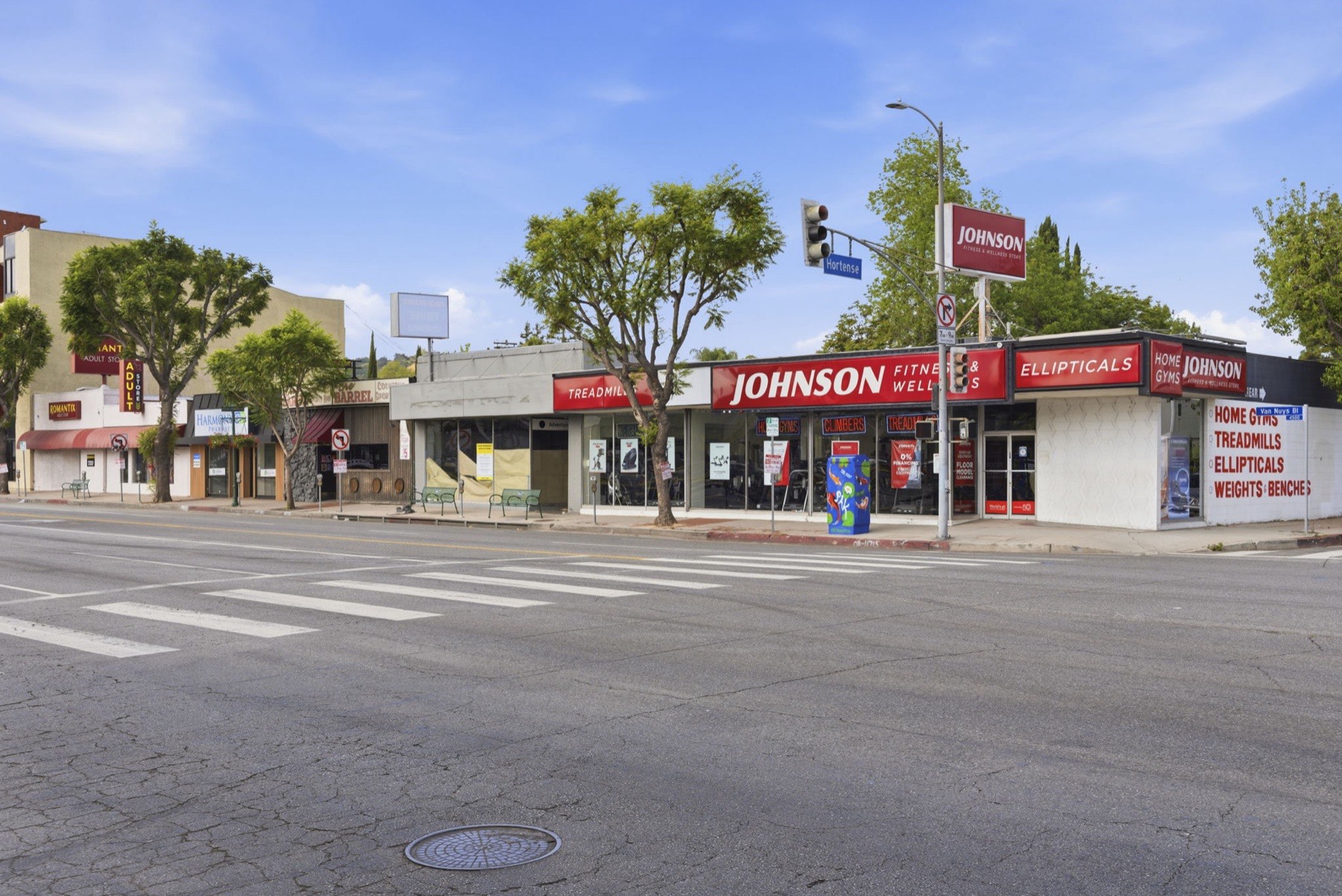 Corner view at Van Nuys Blvd showing Johnson Fitness signage and adjacent retail at the intersection